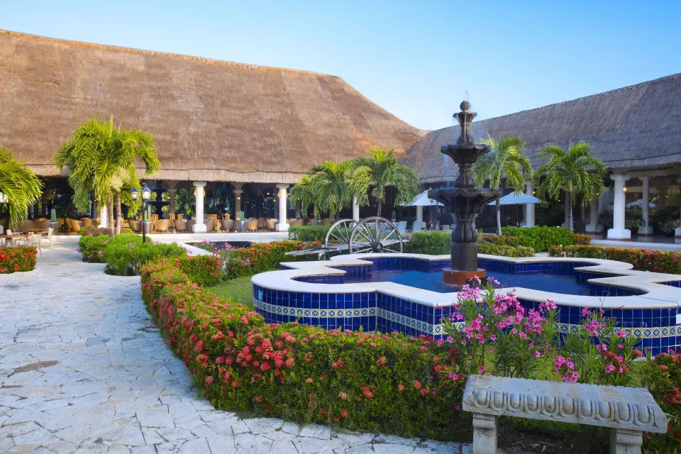 Central courtyard fountain and thatched roofs at Grand Palladium Colonial Resort & Spa