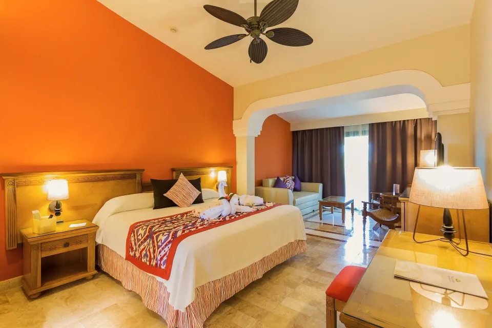 King bed room with archway to living area and ceiling fan at Grand Palladium Colonial Resort & Spa