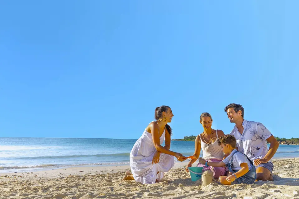 Family playing together on the beach near the water at Grand Palladium Colonial Resort & Spa