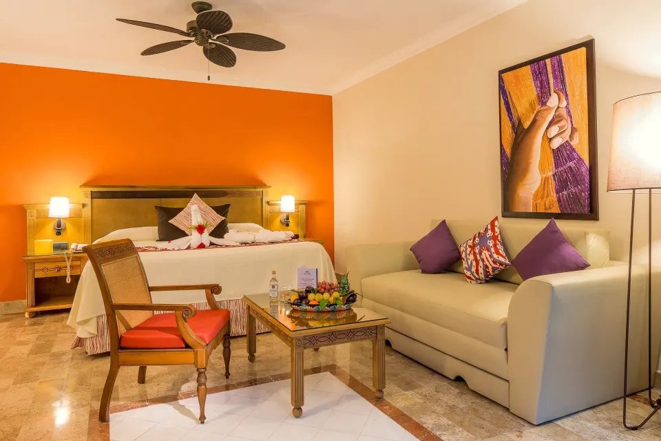 King bed and seating area in a suite at Grand Palladium Colonial Resort & Spa