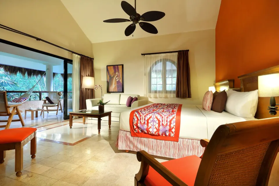 Large junior suite with king bed, seating area and open terrace at Grand Palladium Colonial Resort & Spa