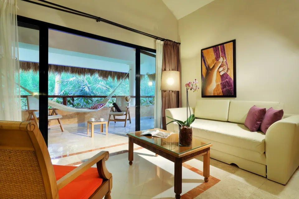 Suite seating area opening to a terrace with hammock at Grand Palladium Colonial Resort & Spa