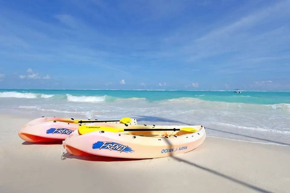 Two kayaks on the sand with turquoise sea at Grand Palladium Colonial Resort & Spa