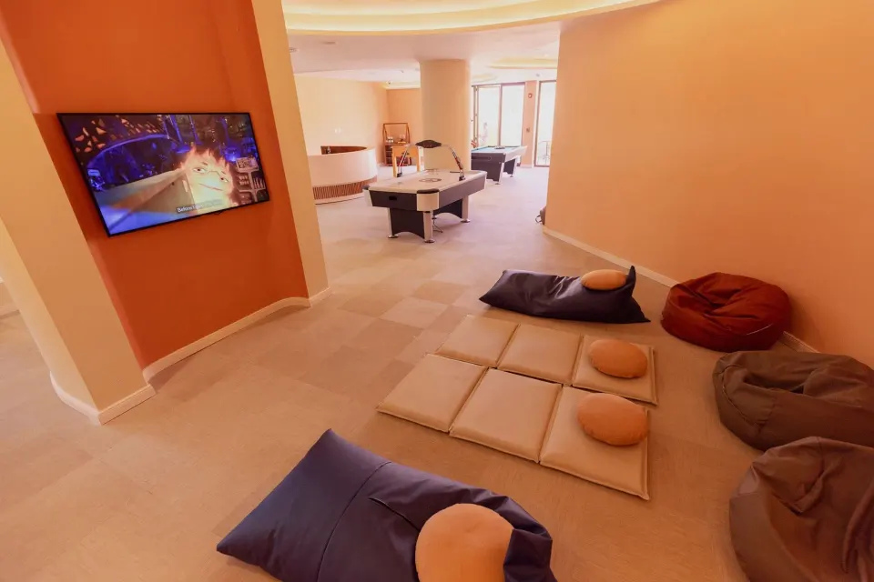 Indoor kids lounge with cushions and arcade screens at Grand Palladium Colonial Resort & Spa