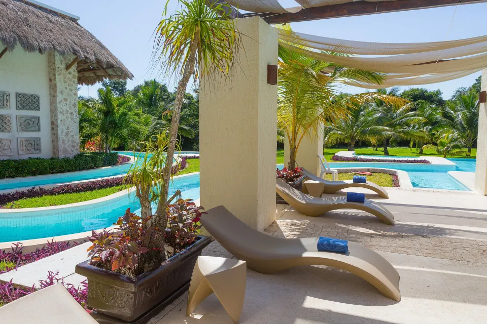 Sun loungers and shaded cabana beside a winding lazy river at Grand Palladium Colonial Resort & Spa