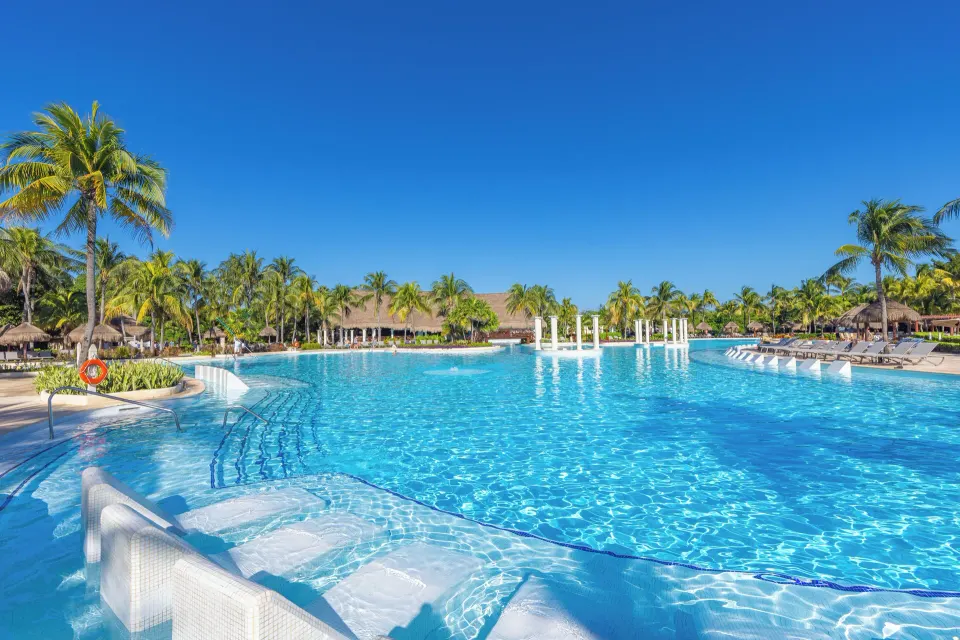 Shallow in-pool loungers and wide resort pool at Grand Palladium Colonial Resort & Spa
