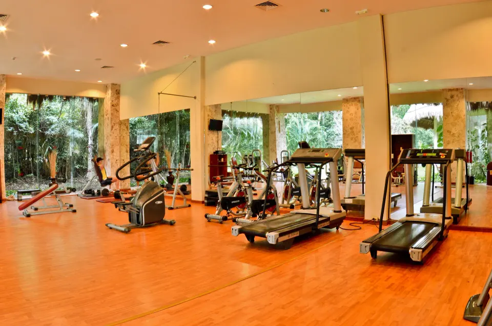 Resort fitness center with cardio machines and mirrored walls at Grand Palladium Colonial Resort & Spa