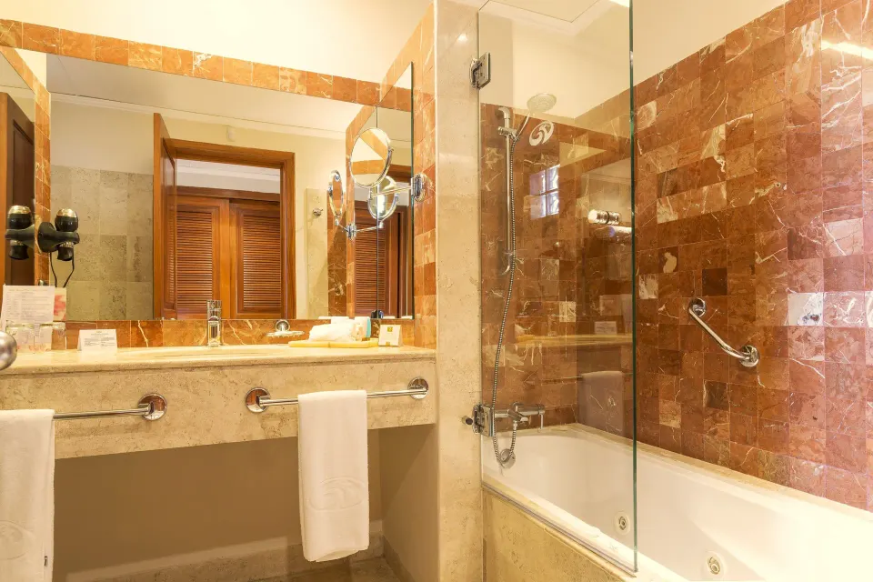 Bathroom with bathtub and glass shower partition at Grand Palladium Colonial Resort & Spa