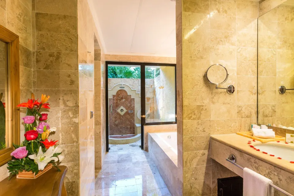 Marble-lined bathroom with tub and outdoor shower area at Grand Palladium Colonial Resort & Spa