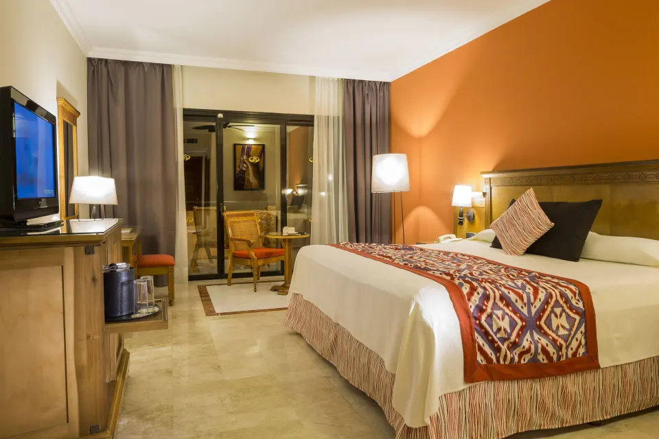 King bed room from foot of bed with TV and balcony at Grand Palladium Colonial Resort & Spa