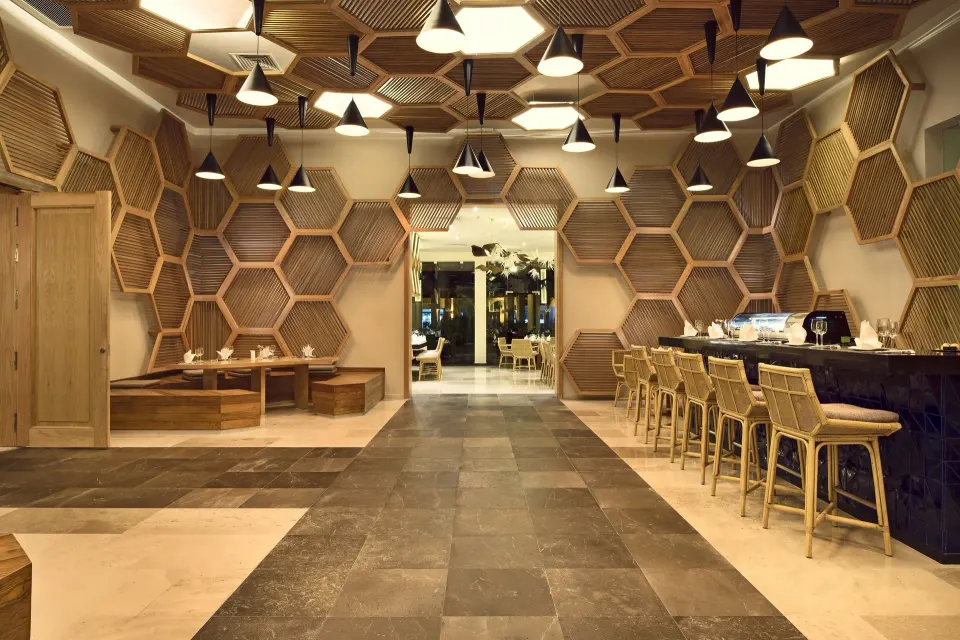 Honeycomb-style wood paneled lounge and bar area at Grand Palladium Colonial Resort & Spa