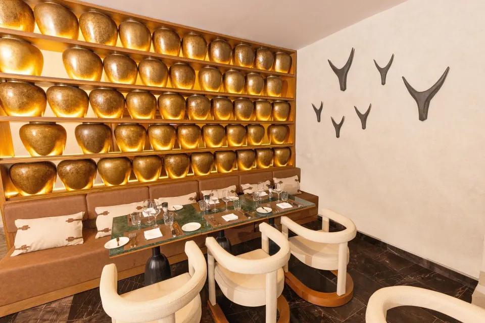 Private dining booth with decorative golden bowls on wall at Grand Palladium Colonial Resort & Spa