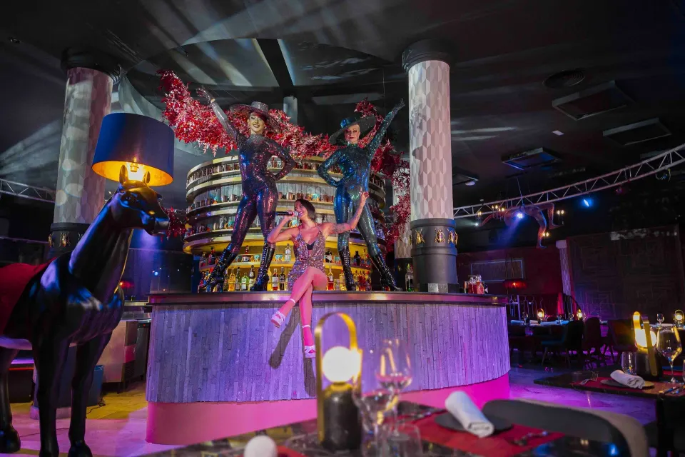 Lively stage and bar area with performers and dramatic lighting at Grand Palladium Colonial Resort & Spa