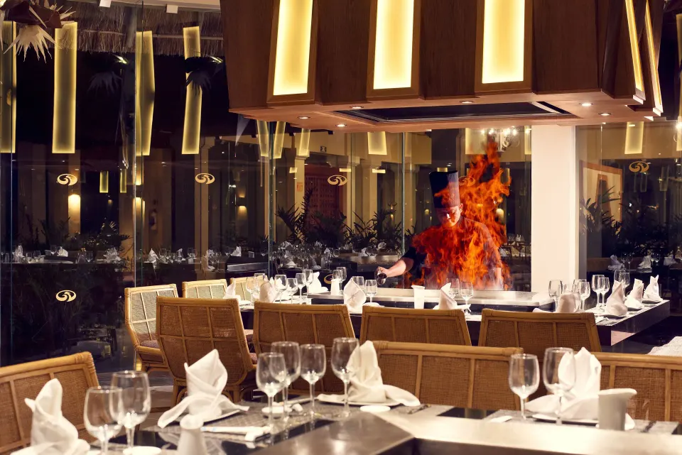 Teppanyaki chef cooking at a live grill station in a restaurant at Grand Palladium Colonial Resort & Spa