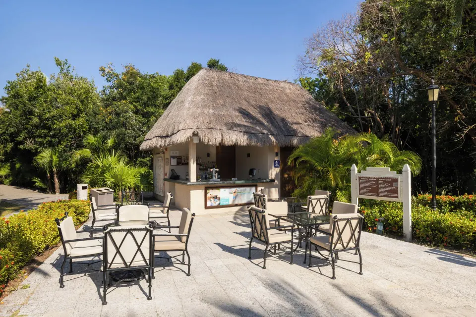 Thatched outdoor bar with seating at Grand Palladium Colonial Resort & Spa
