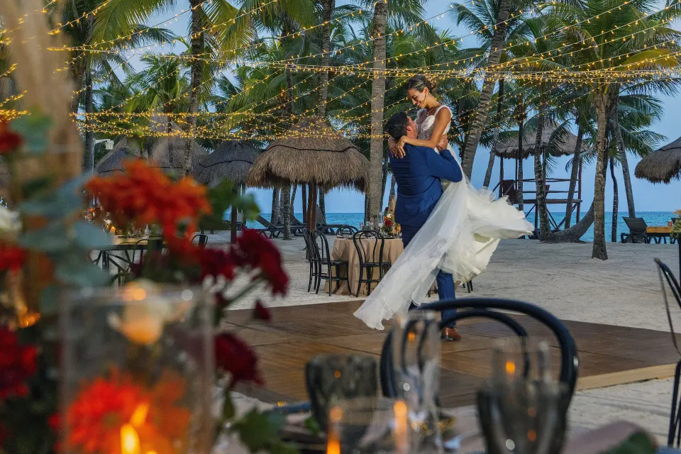 Bride and groom dancing on a decorated beach at Grand Palladium Colonial Resort & Spa