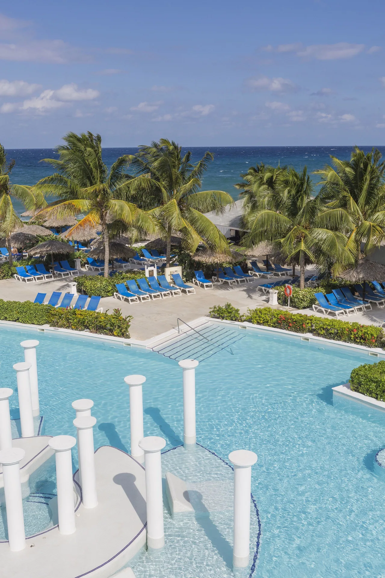 Beachfront pool, palms, and ocean at Grand Palladium Jamaica Resort & Spa.