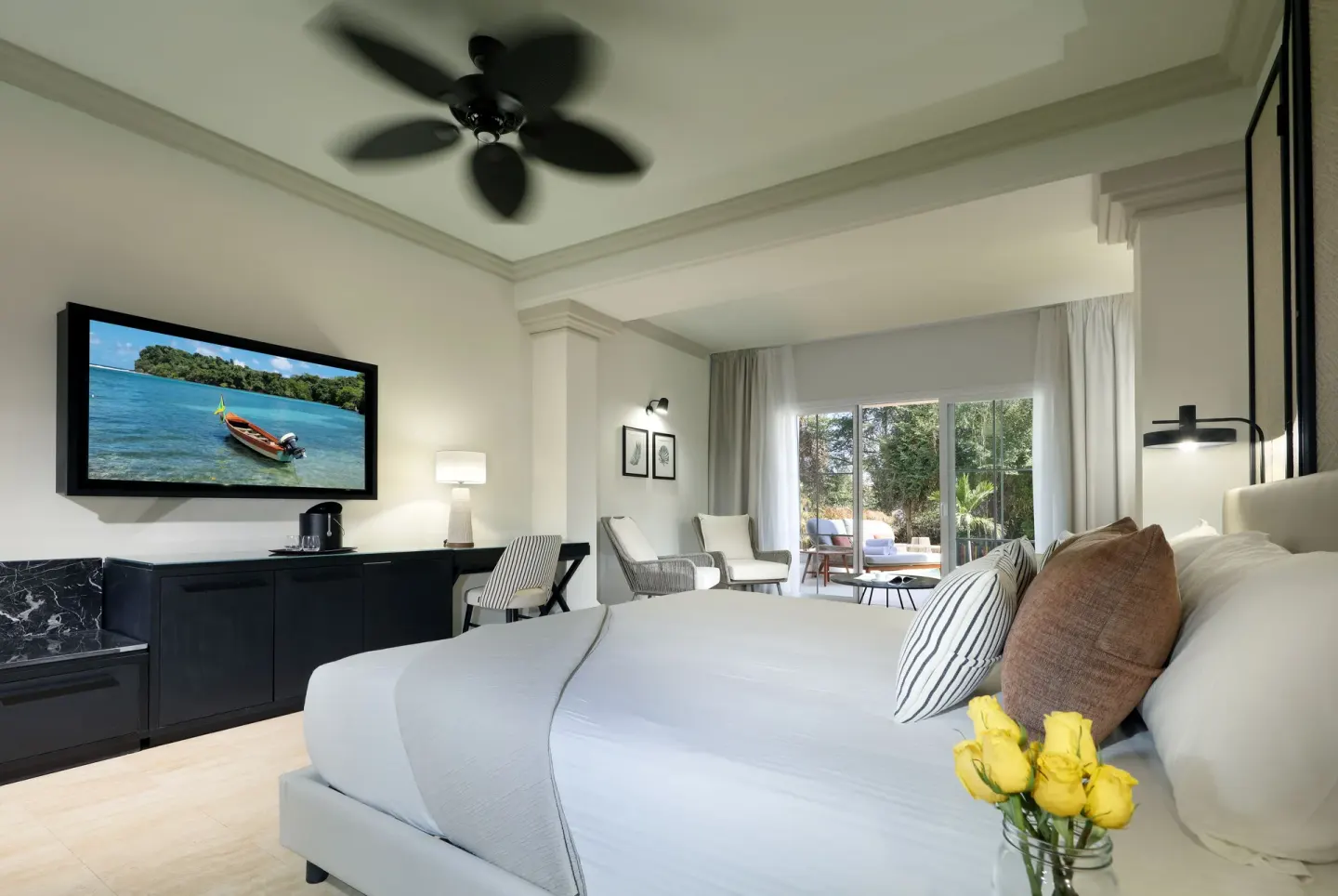 King bed guest room with TV and terrace doors at Grand Palladium Jamaica Resort & Spa.