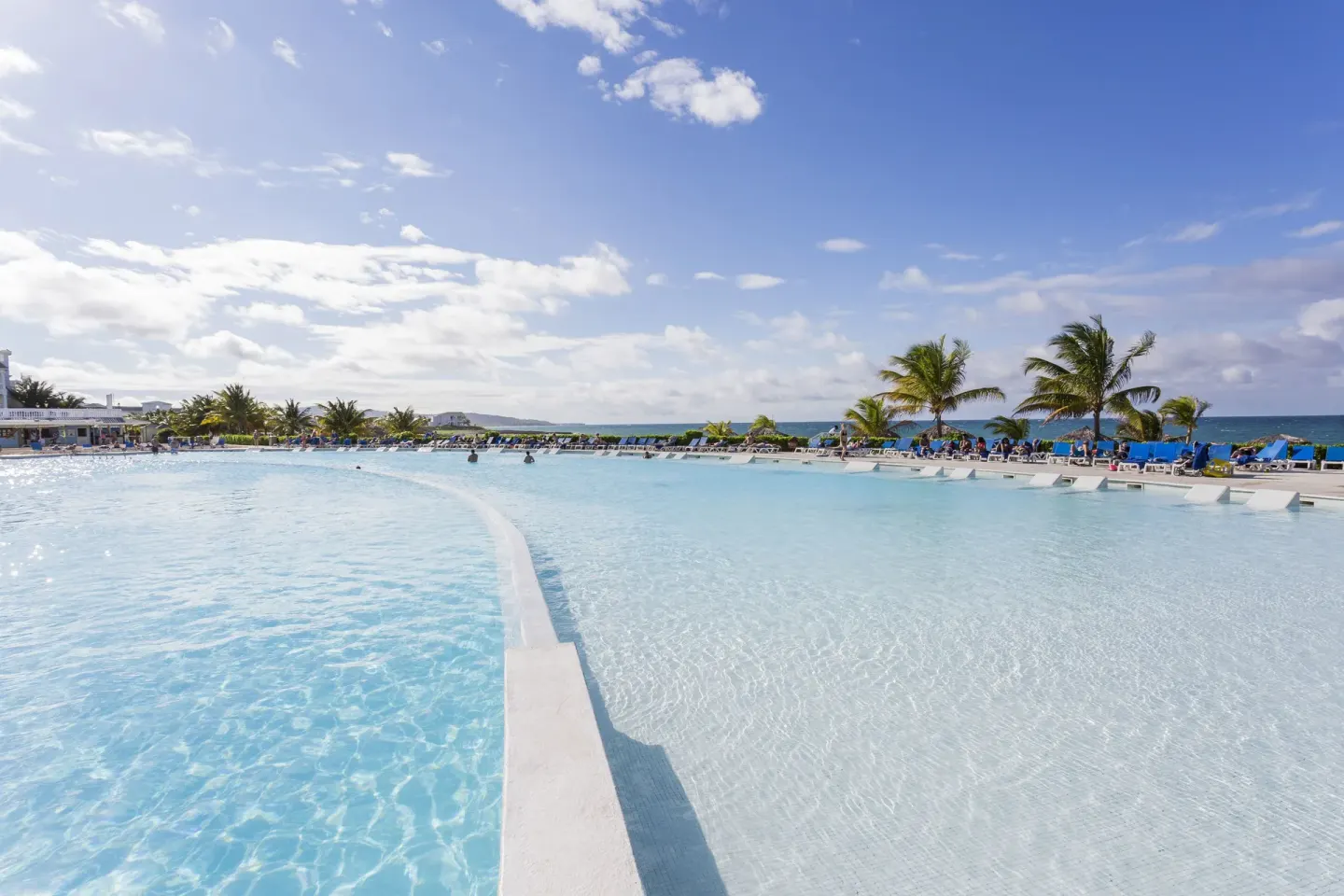 Large oceanfront pool with palm trees at Grand Palladium Jamaica Resort & Spa.