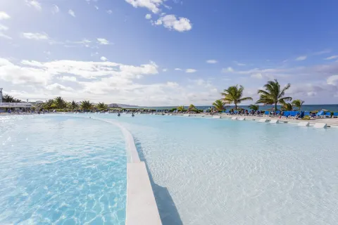 Large oceanfront pool with palm trees at Grand Palladium Jamaica Resort & Spa.