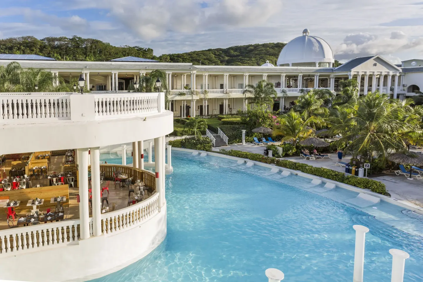 Pool beside a white terrace and domed resort building at Grand Palladium Jamaica Resort & Spa.