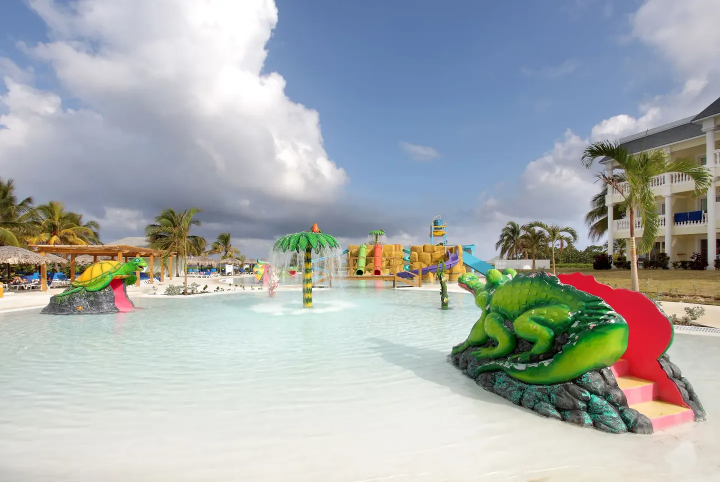 Splash pool with animal slides and resort building at Grand Palladium Jamaica Resort & Spa.