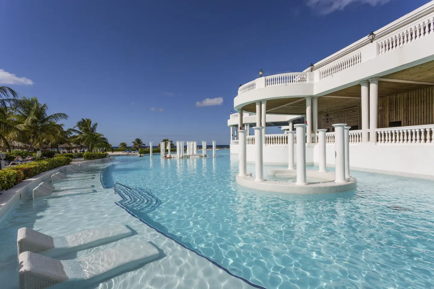 Swim-up pool area with white columns at Grand Palladium Jamaica Resort & Spa.