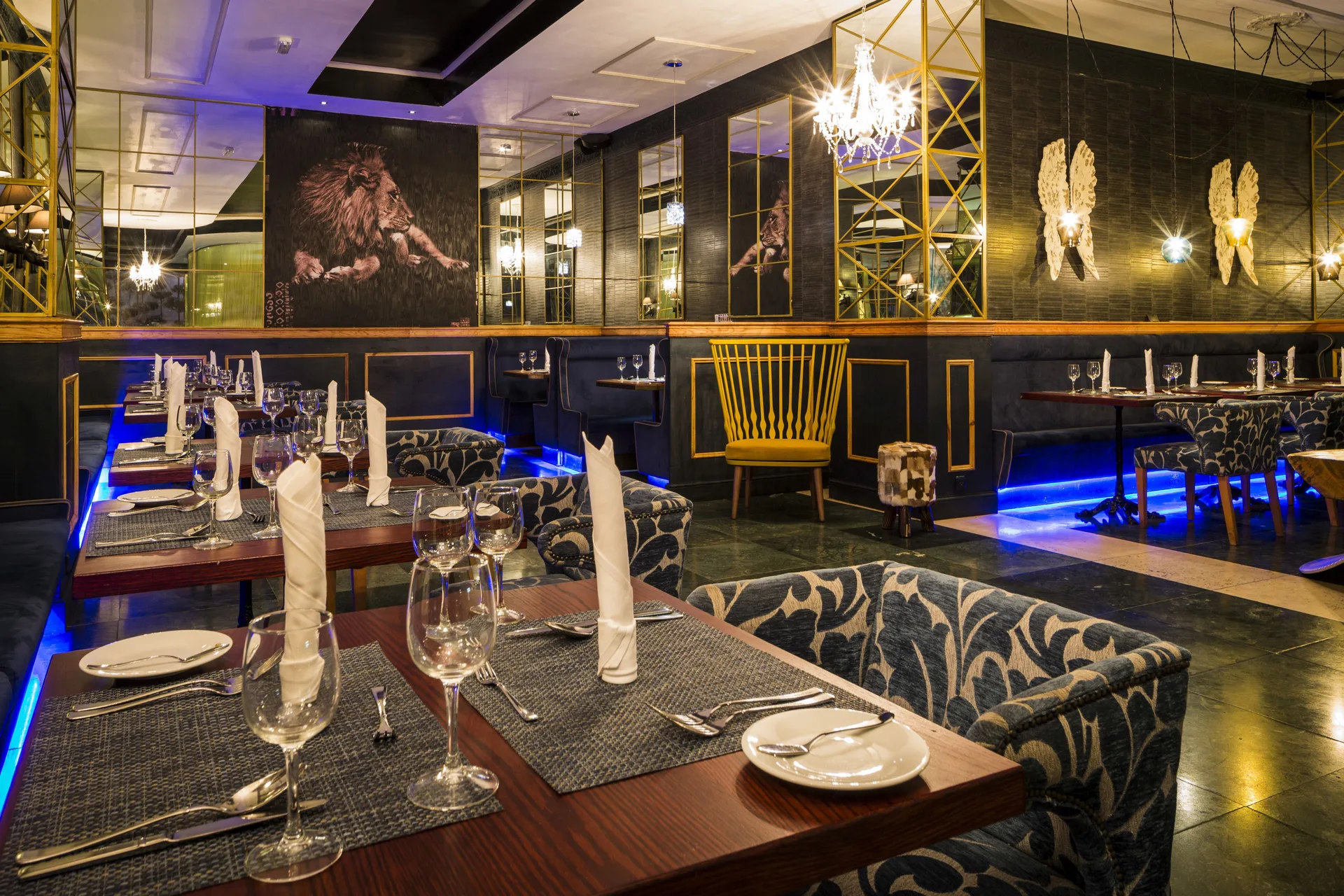 Dramatic dining room with lion artwork and set tables at Grand Palladium Jamaica Resort & Spa.
