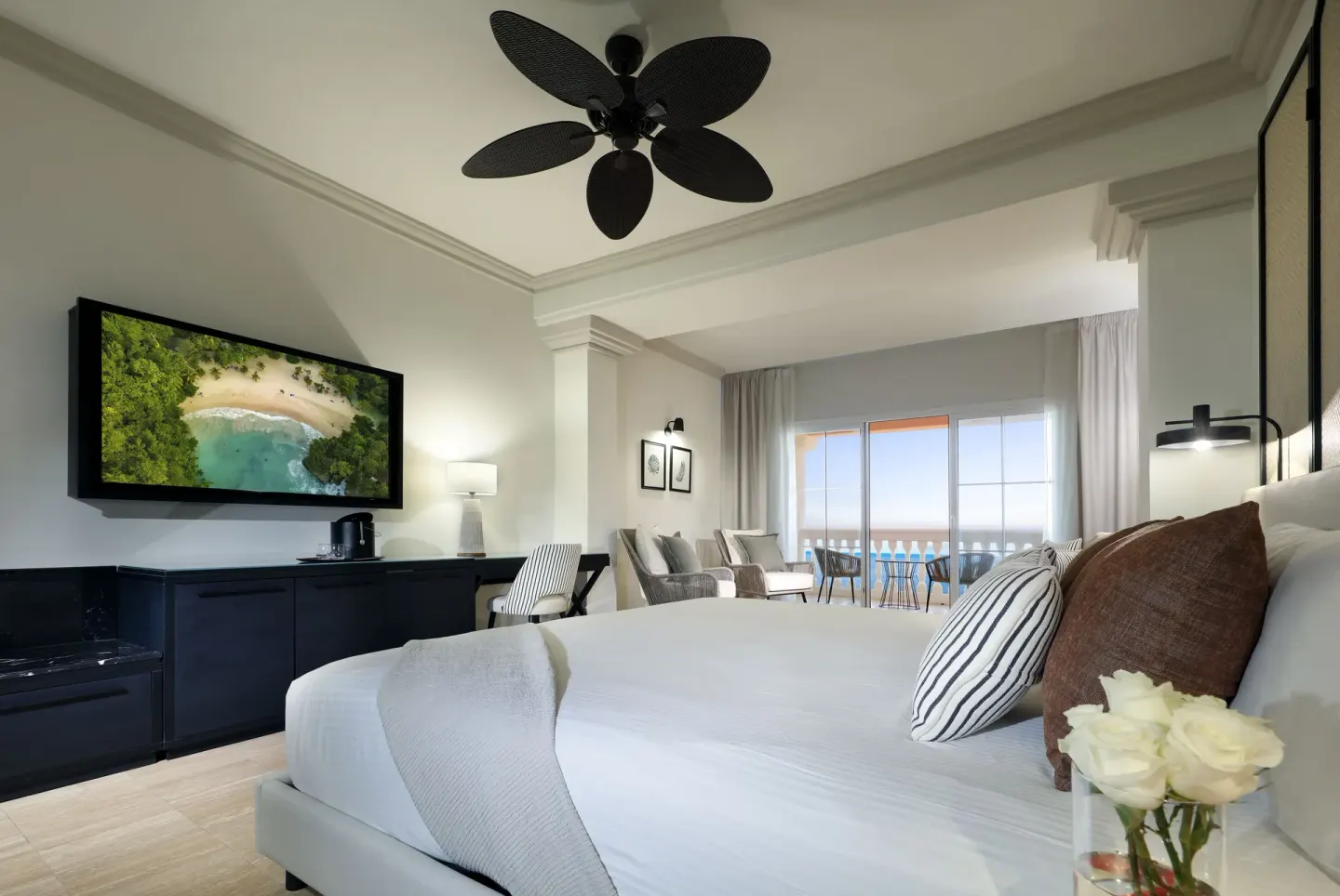 Junior Suite Oceanfront king bed with TV and balcony at Grand Palladium Jamaica Resort & Spa.