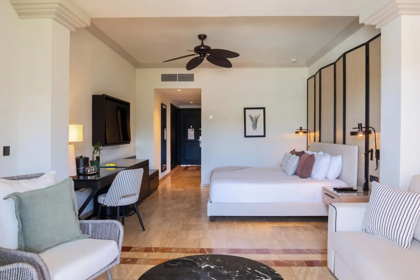 Junior Suite king bed, seating, and desk at Grand Palladium Jamaica Resort & Spa.