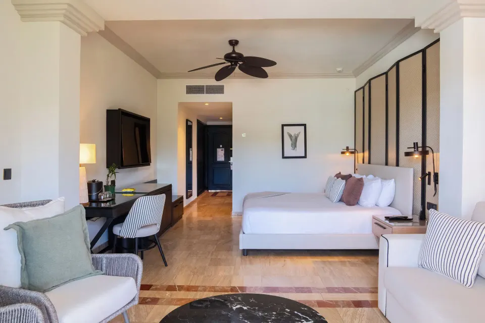 Junior Suite king bed, seating, and desk at Grand Palladium Jamaica Resort & Spa.