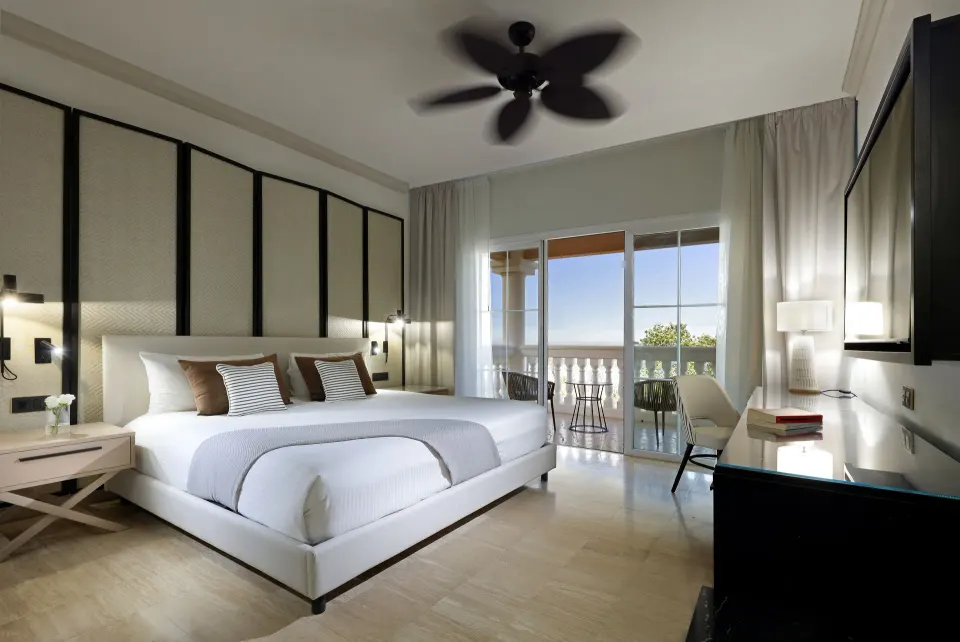 Oceanfront suite king bed and balcony view at Grand Palladium Jamaica Resort & Spa.