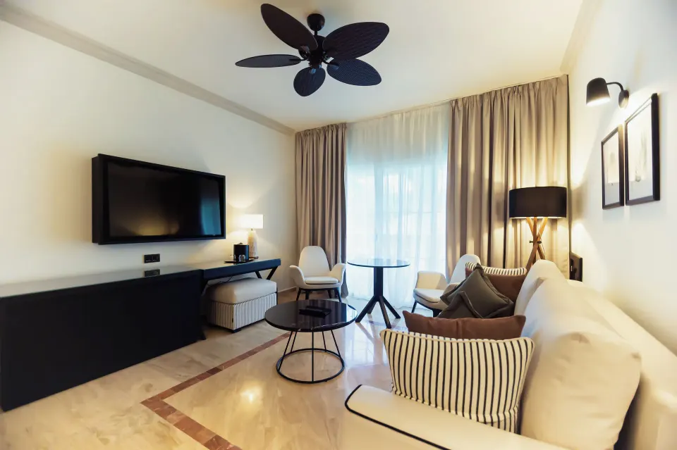 Oceanfront suite seating area with TV and sofa at Grand Palladium Jamaica Resort & Spa.