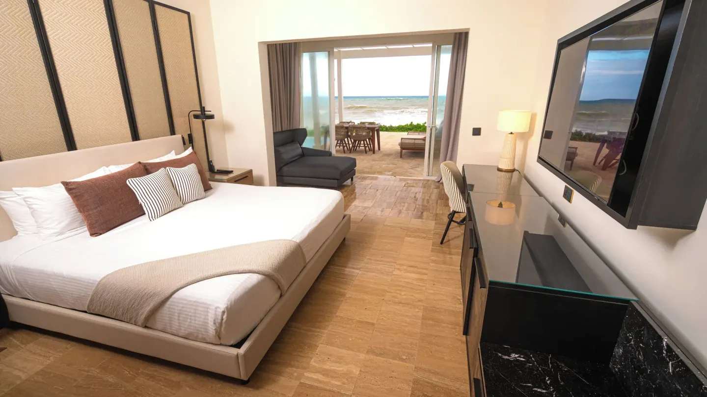 Suite bedroom with king bed and oceanfront terrace at Grand Palladium Jamaica Resort & Spa.