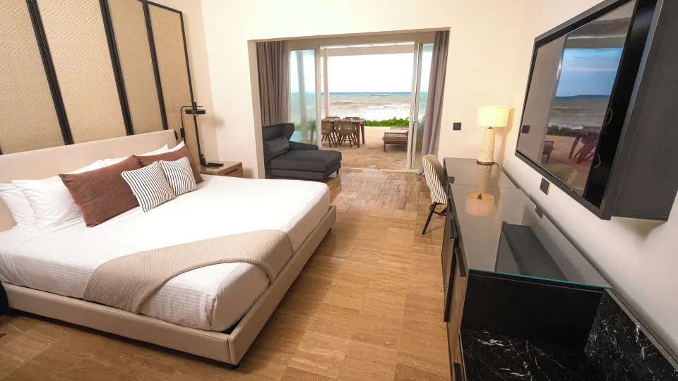 Suite bedroom with king bed and oceanfront terrace at Grand Palladium Jamaica Resort & Spa.