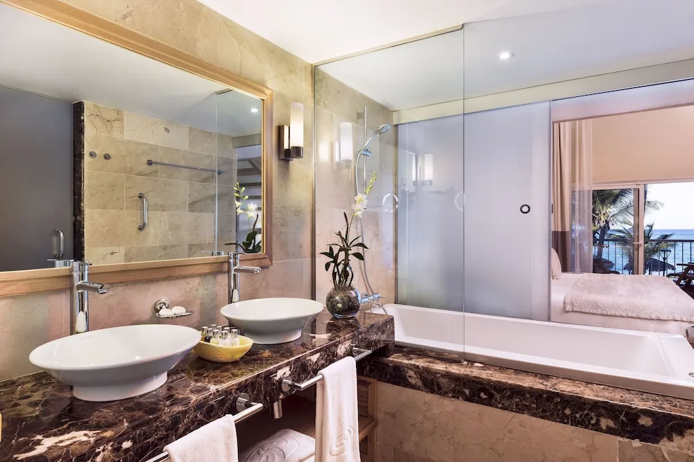 Bathroom double vanity and tub beside bedroom at Grand Palladium Palace Resort Spa & Casino.