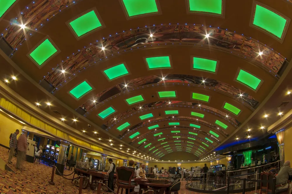 Casino gaming floor with green ceiling lights at Grand Palladium Palace Resort Spa & Casino.