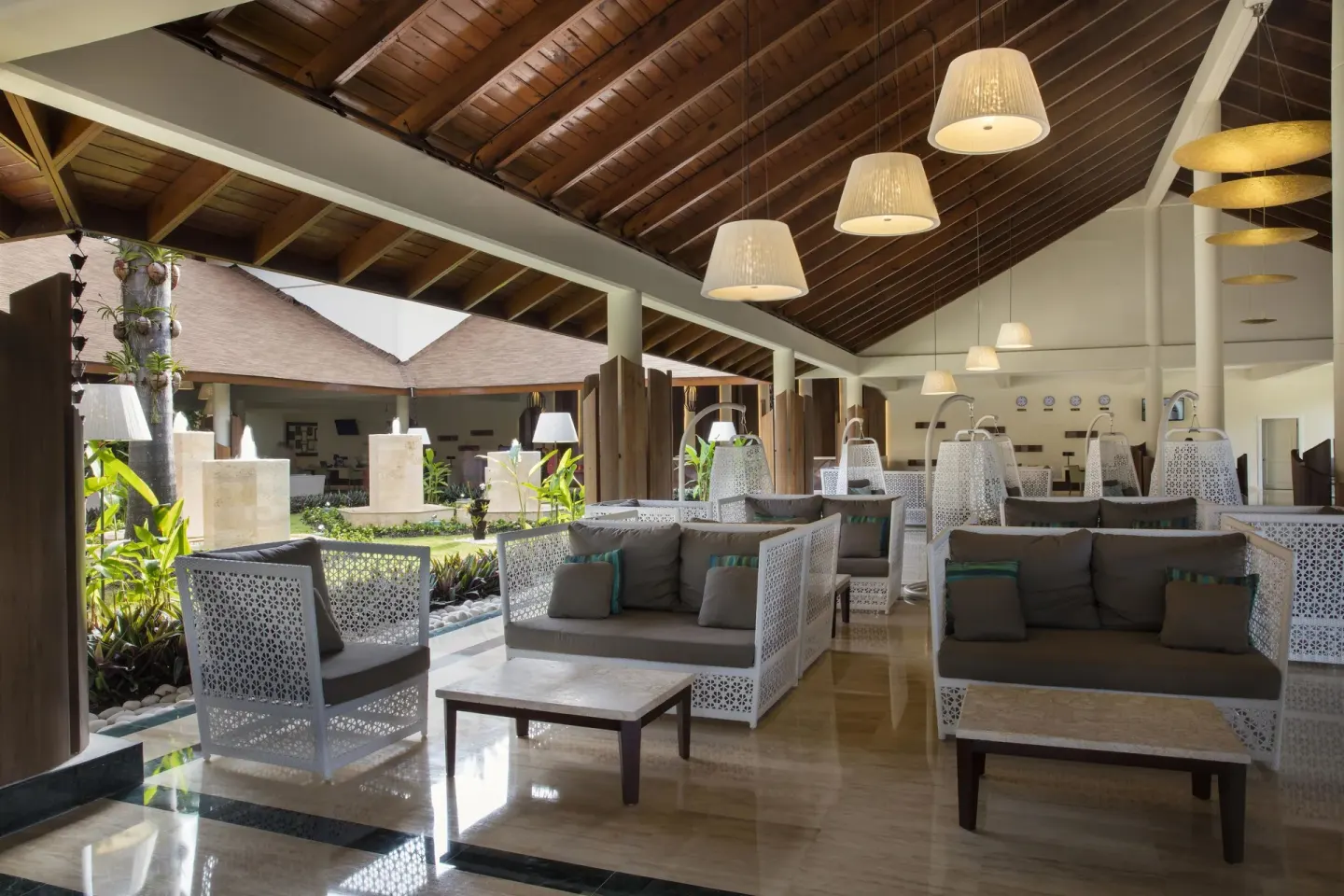 Covered lobby lounge with white seating at Grand Palladium Palace Resort Spa & Casino.