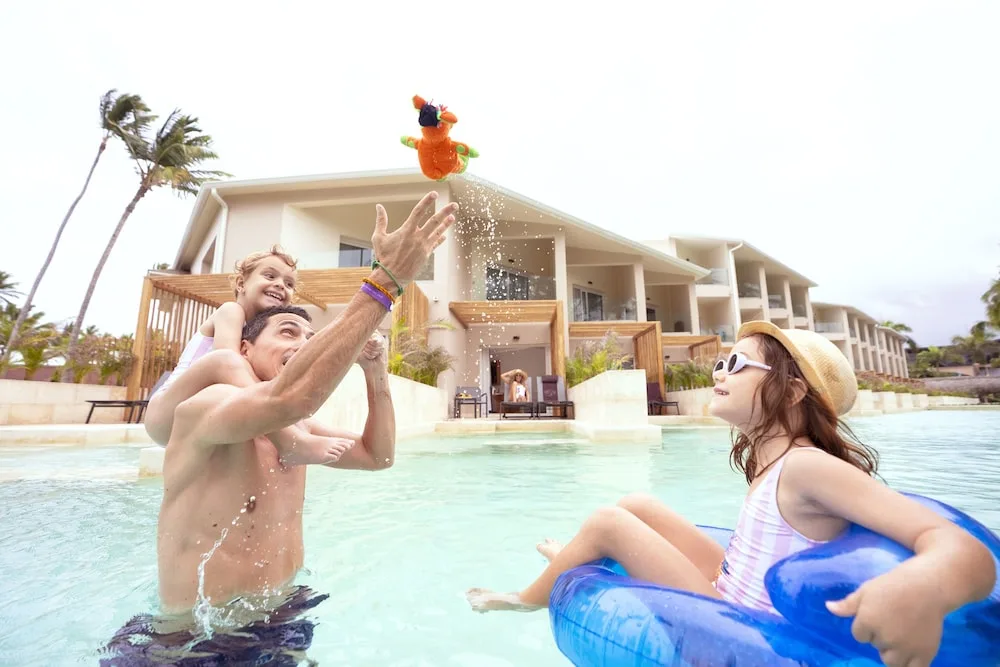 Family playing in the pool at Grand Palladium Palace Resort Spa & Casino.