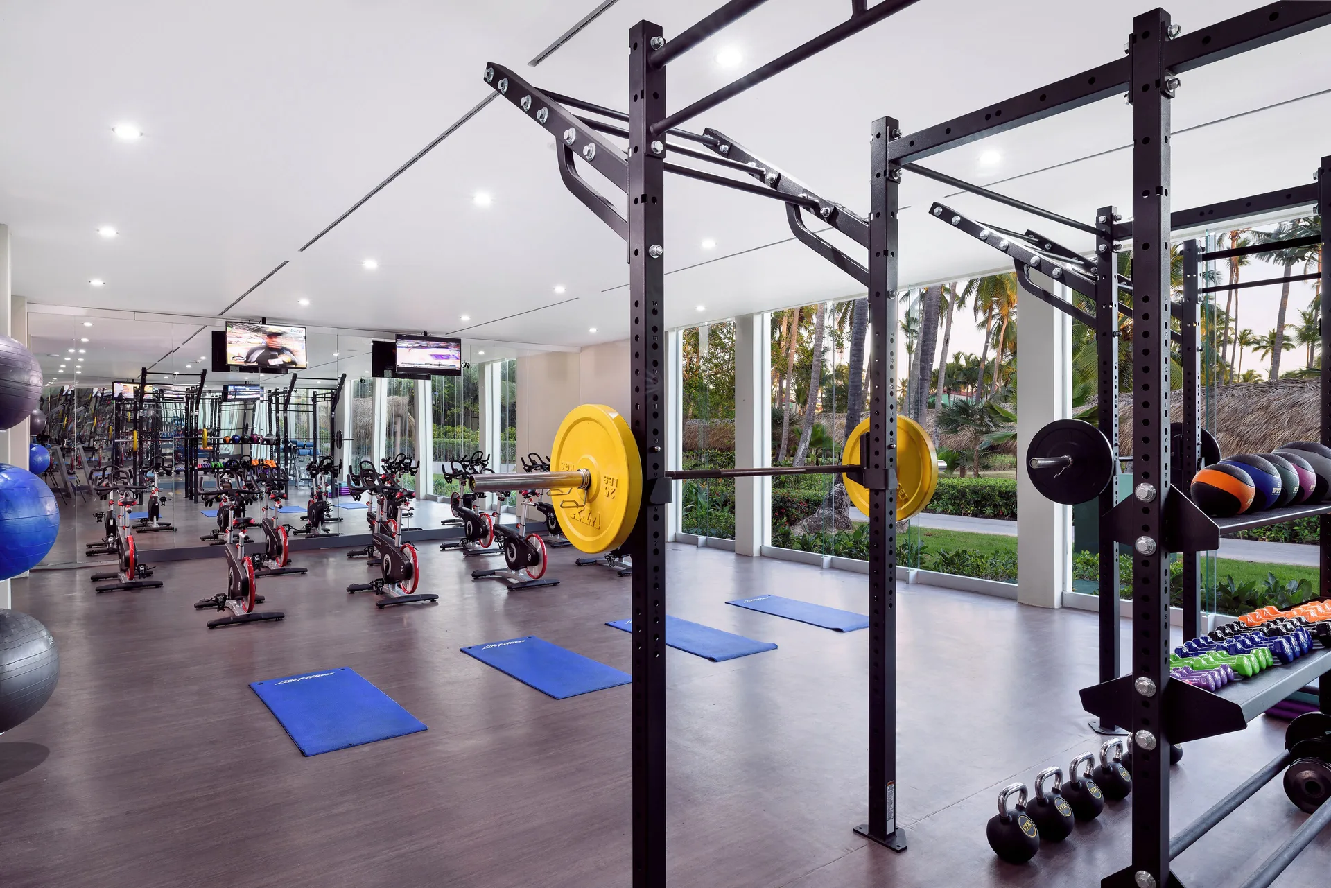 Fitness room with weight racks and spin bikes at Grand Palladium Palace Resort Spa & Casino.