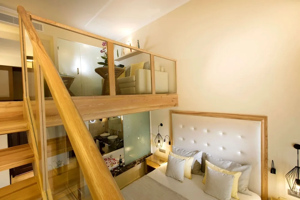 Loft-style guest room with stairs and a bed at Grand Palladium Palace Resort Spa & Casino.