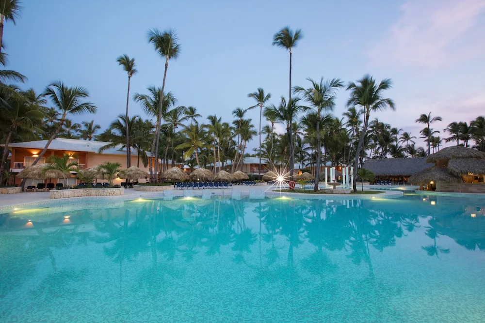 Resort pool with palms at Grand Palladium Palace Resort Spa & Casino.