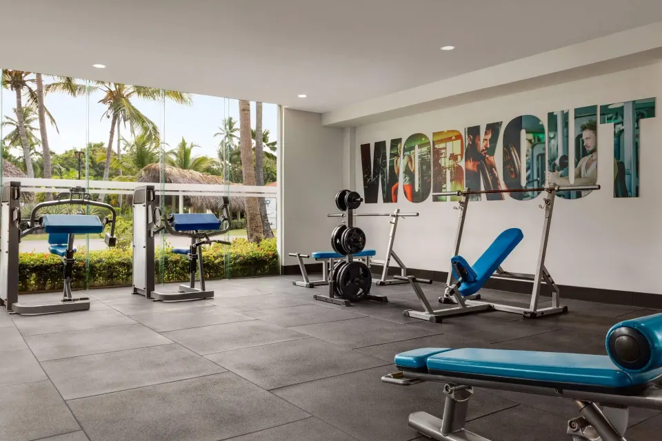 Strength-training area with blue benches at Grand Palladium Palace Resort Spa & Casino.