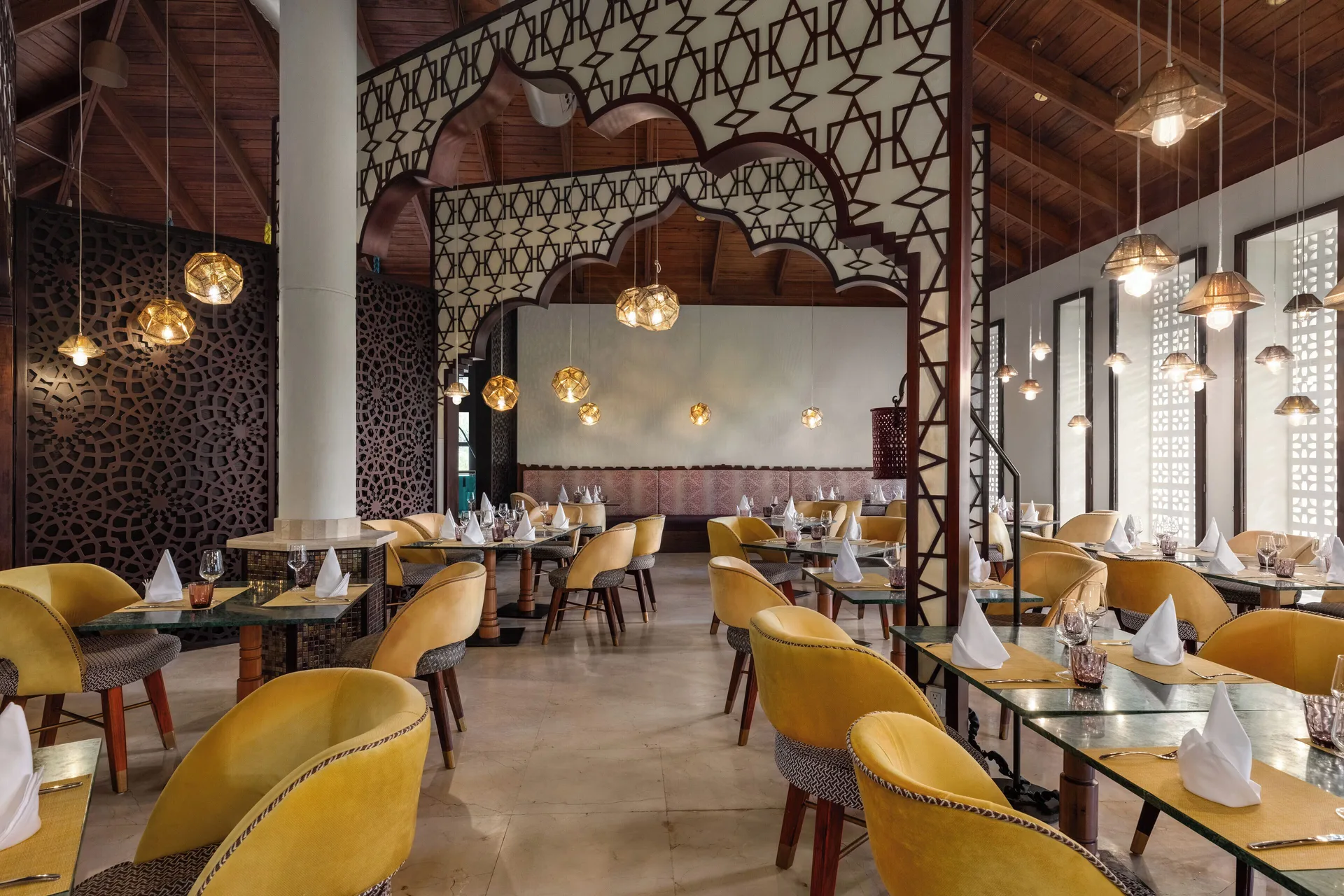 Arched dining room with yellow chairs at Grand Palladium Palace Resort Spa & Casino.