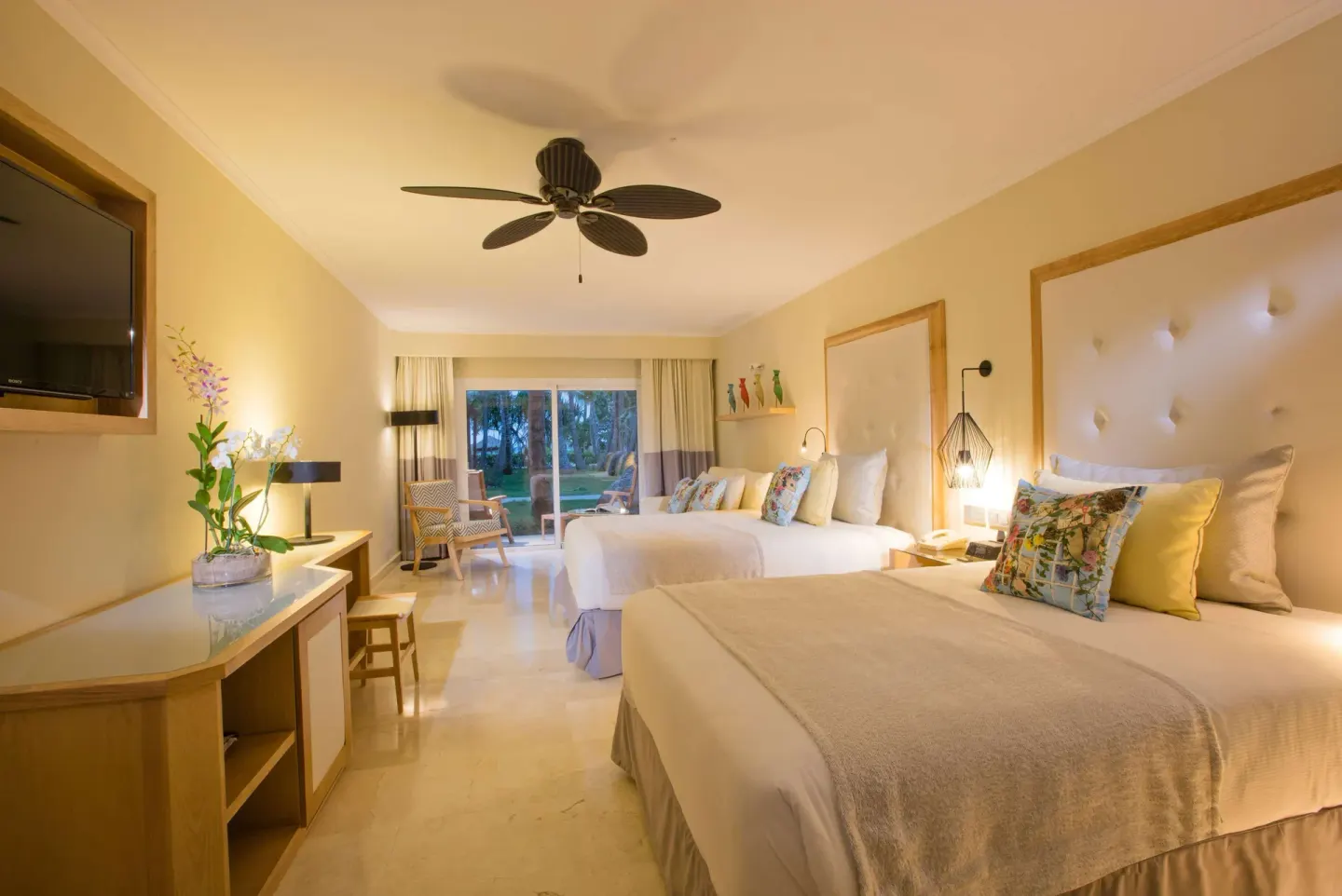 Deluxe Garden View room with two beds, desk and patio doors at Grand Palladium Palace Resort Spa & Casino.