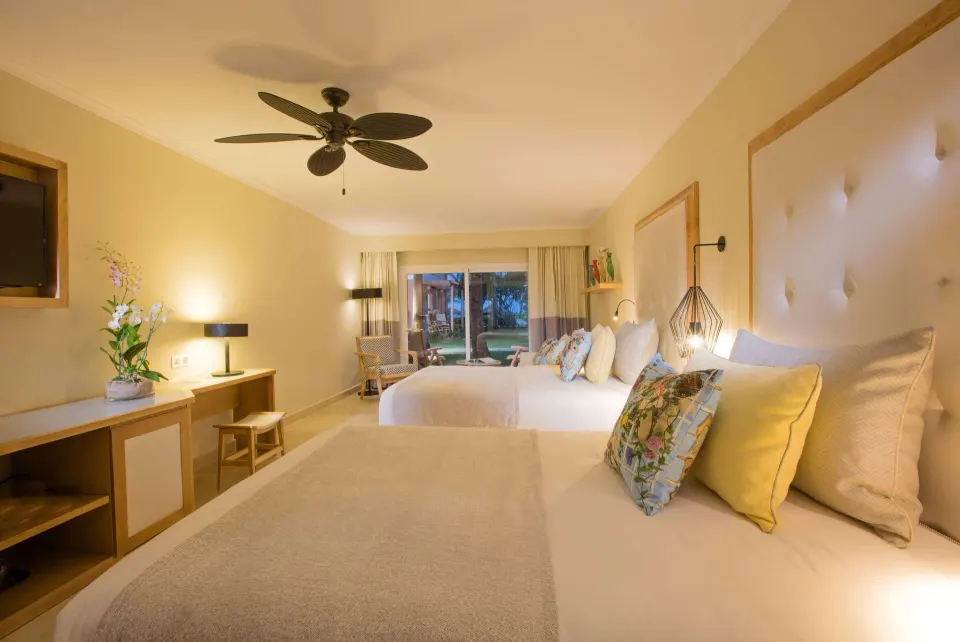 Deluxe Garden View room with two beds and garden-facing glass doors at Grand Palladium Palace Resort Spa & Casino.