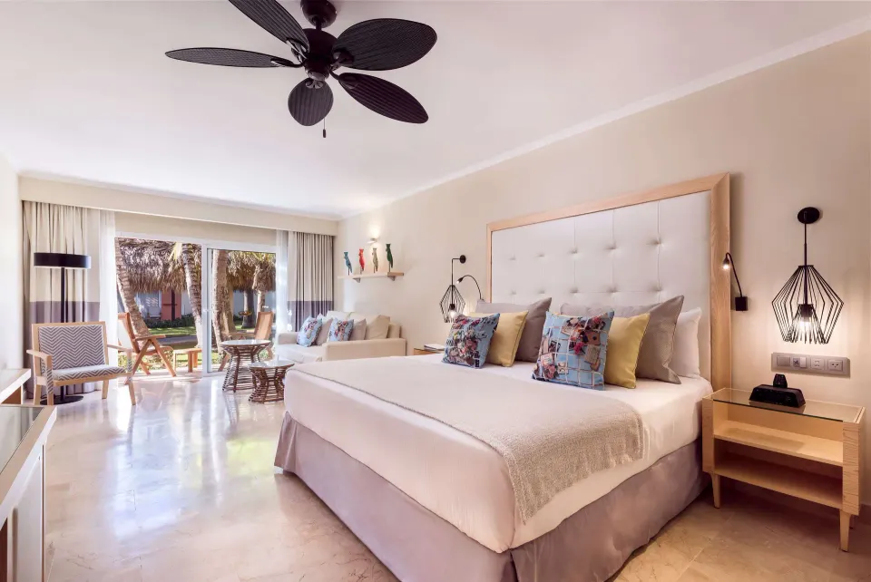 Junior Suite Beachside king bed opening to a patio at Grand Palladium Palace Resort Spa & Casino.