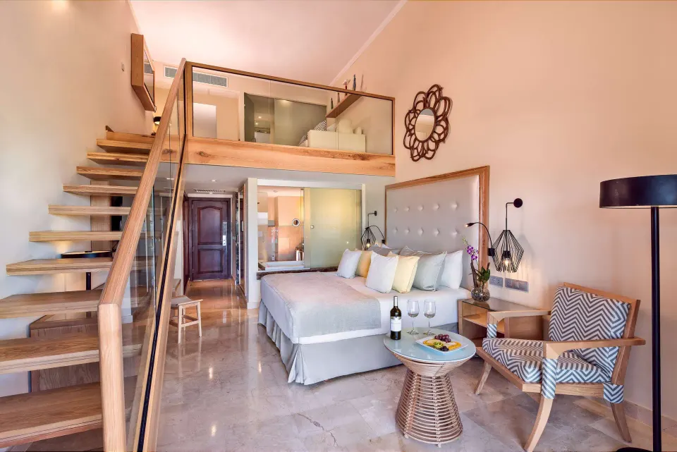 Loft Suite Garden View with king bed and staircase at Grand Palladium Palace Resort Spa & Casino.