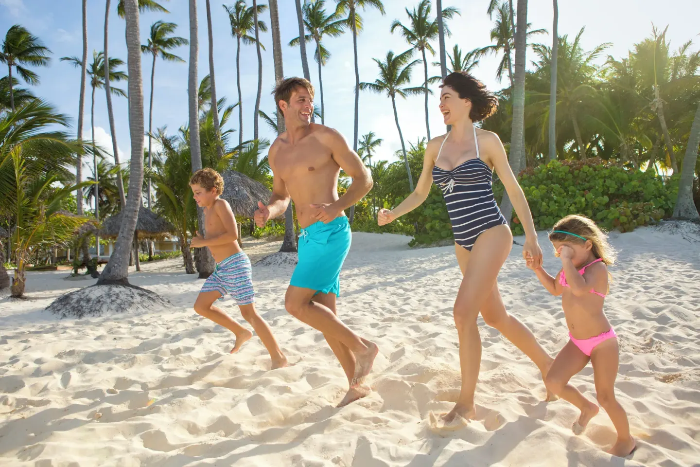 Family walking on the sandy beach at Grand Palladium Punta Cana Resort & Spa.