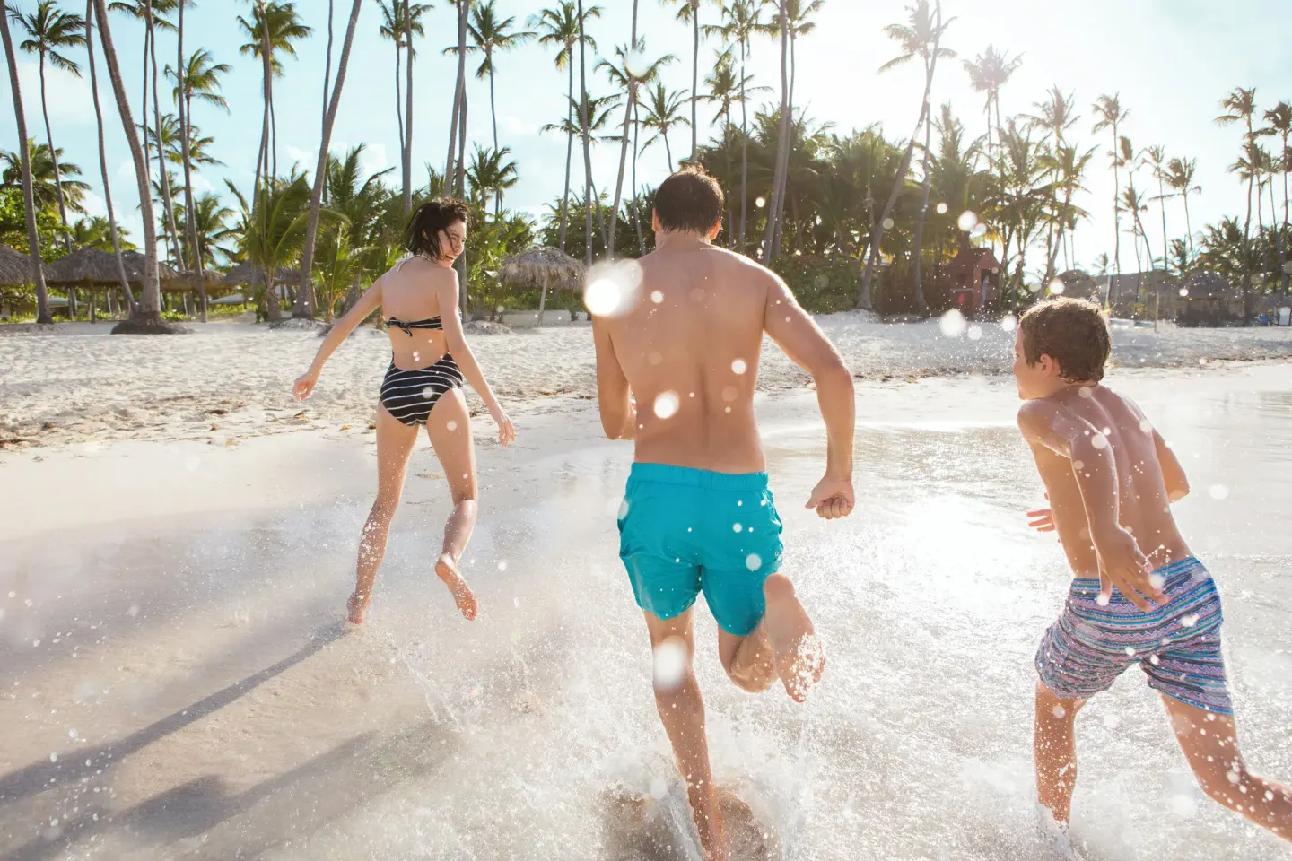 Family splashing at the shoreline at Grand Palladium Punta Cana Resort & Spa.